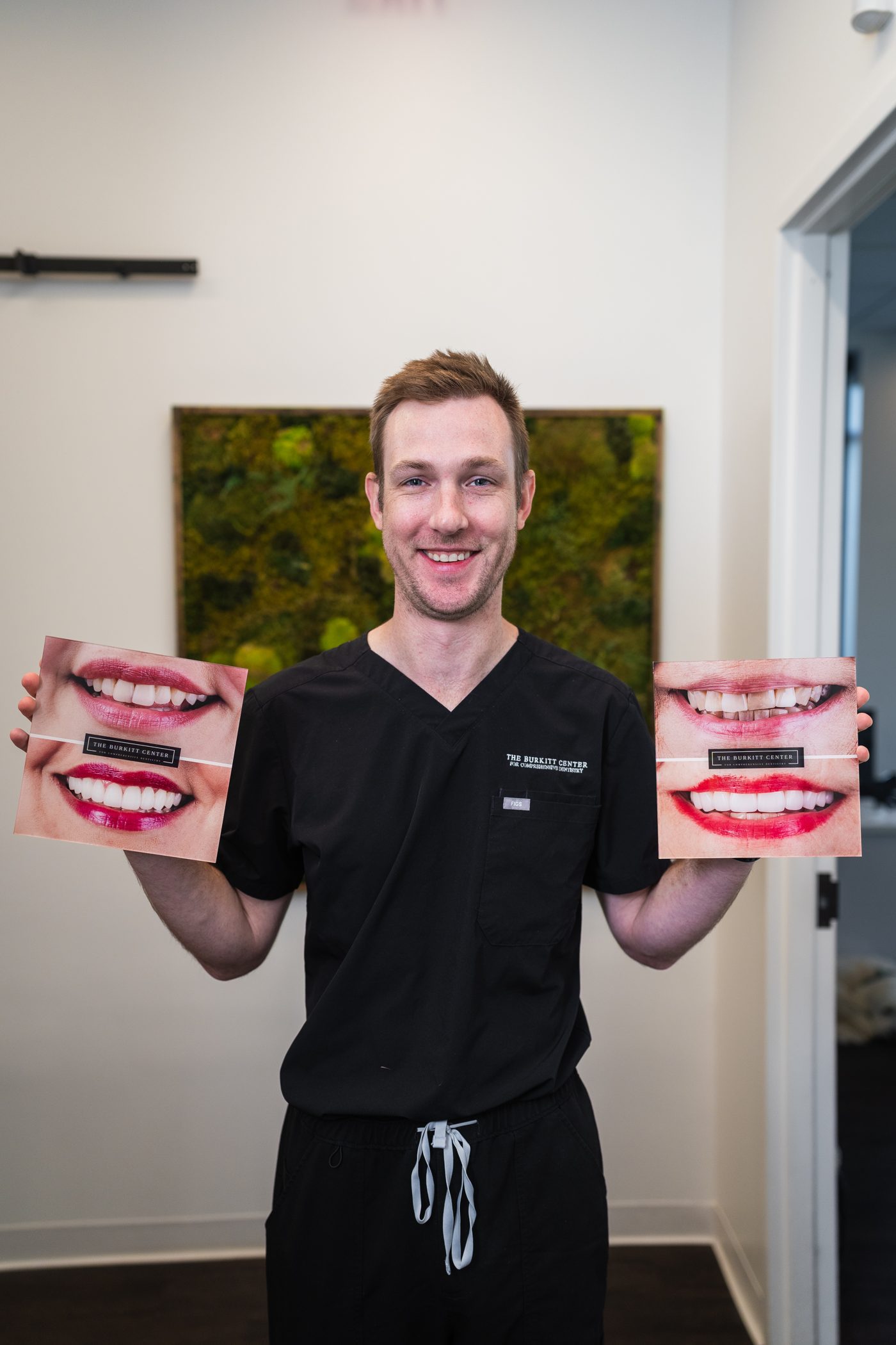 Dr. Hayden holding two before-and-after smile photos from the practice